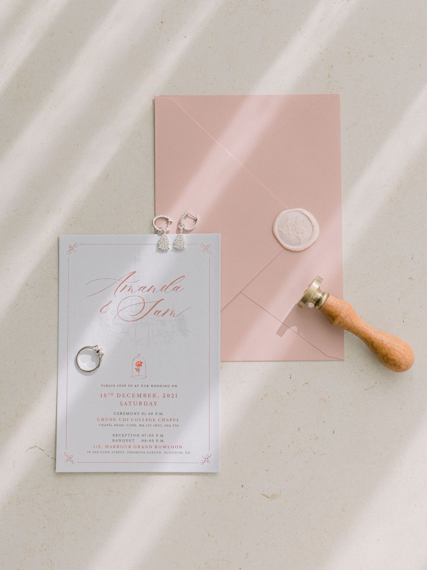 Wedding invitation and wax seal in blush pink with elegant calligraphy.