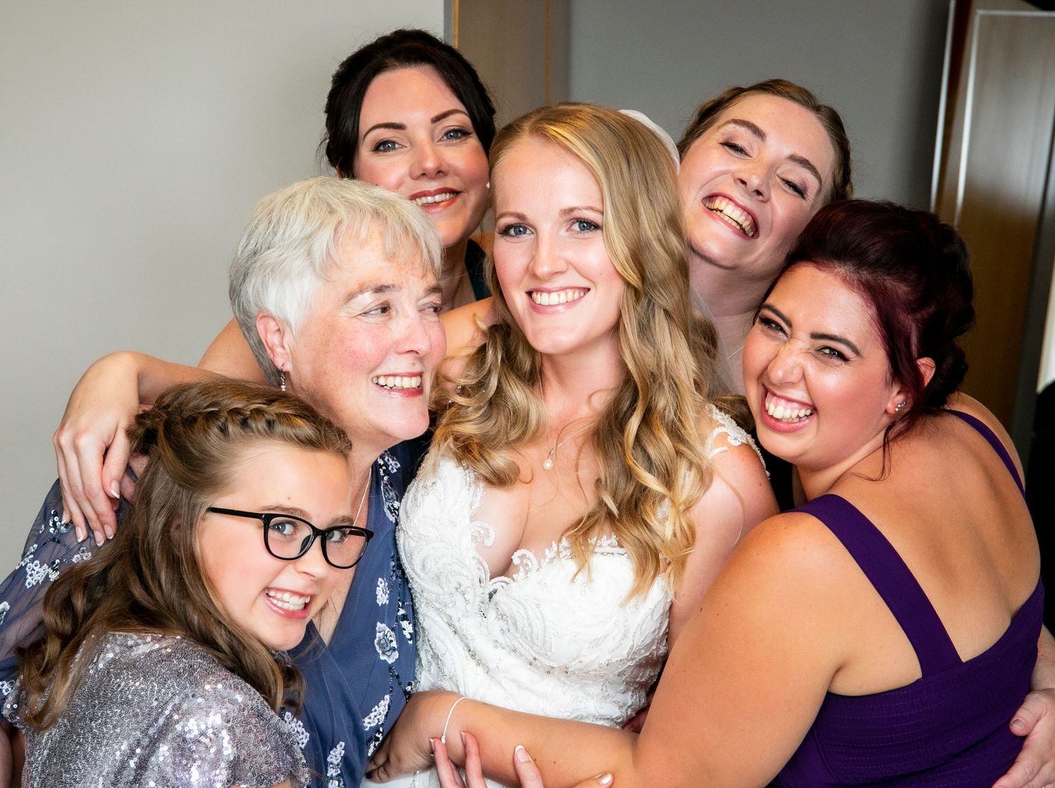 Group photo of wedding party members sharing joyful moment together.