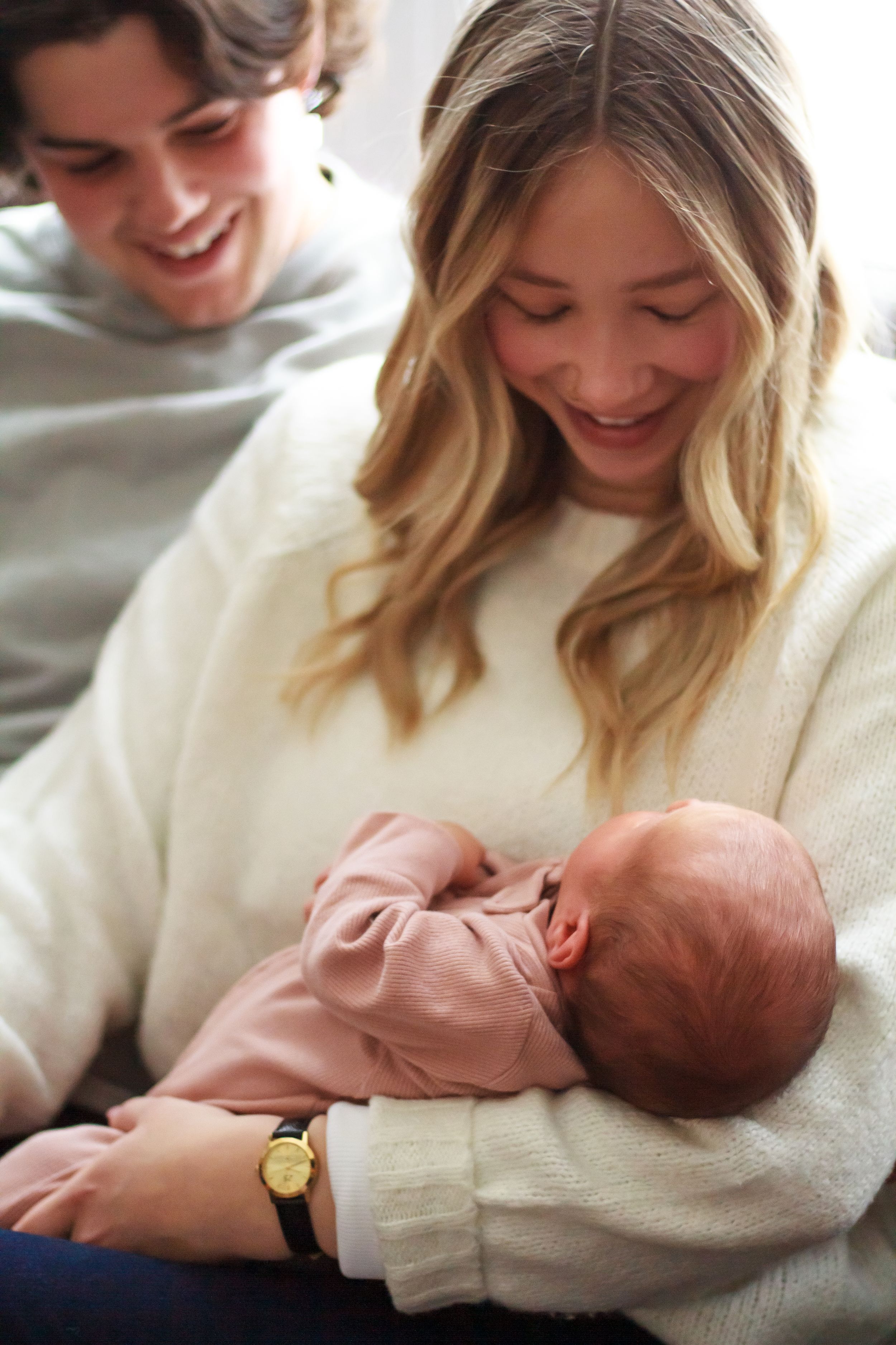 Close up of new parents admiring newborn baby.