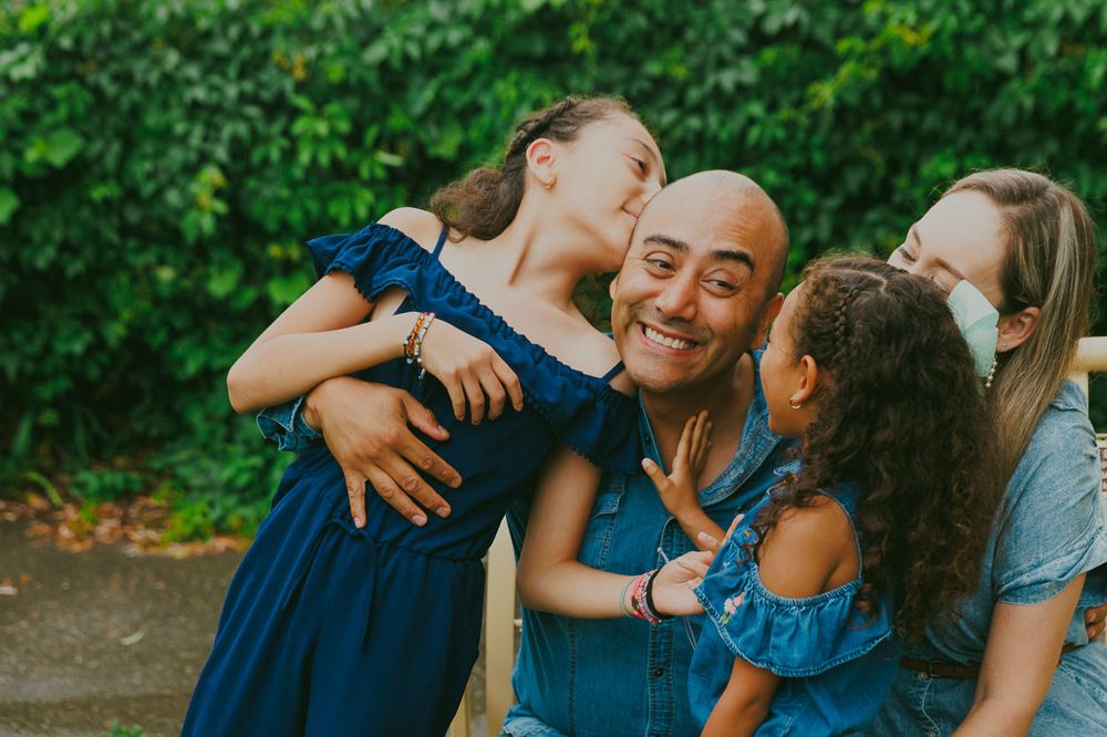 A family shares laughter and embraces while spending time together outdoors.