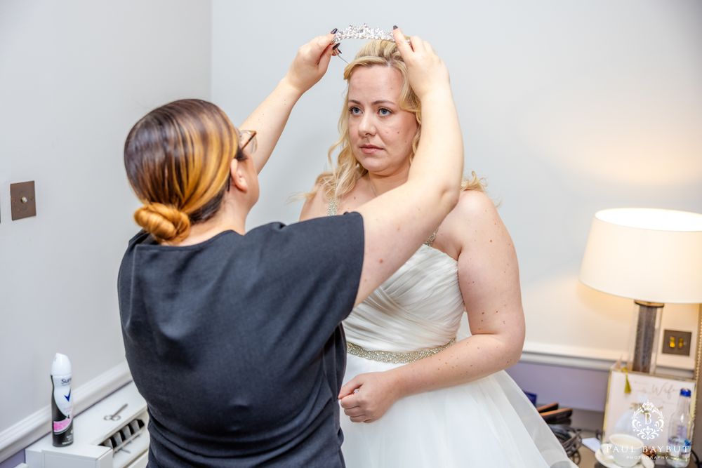 Final bridal preparations taking place in an elegant hotel room.