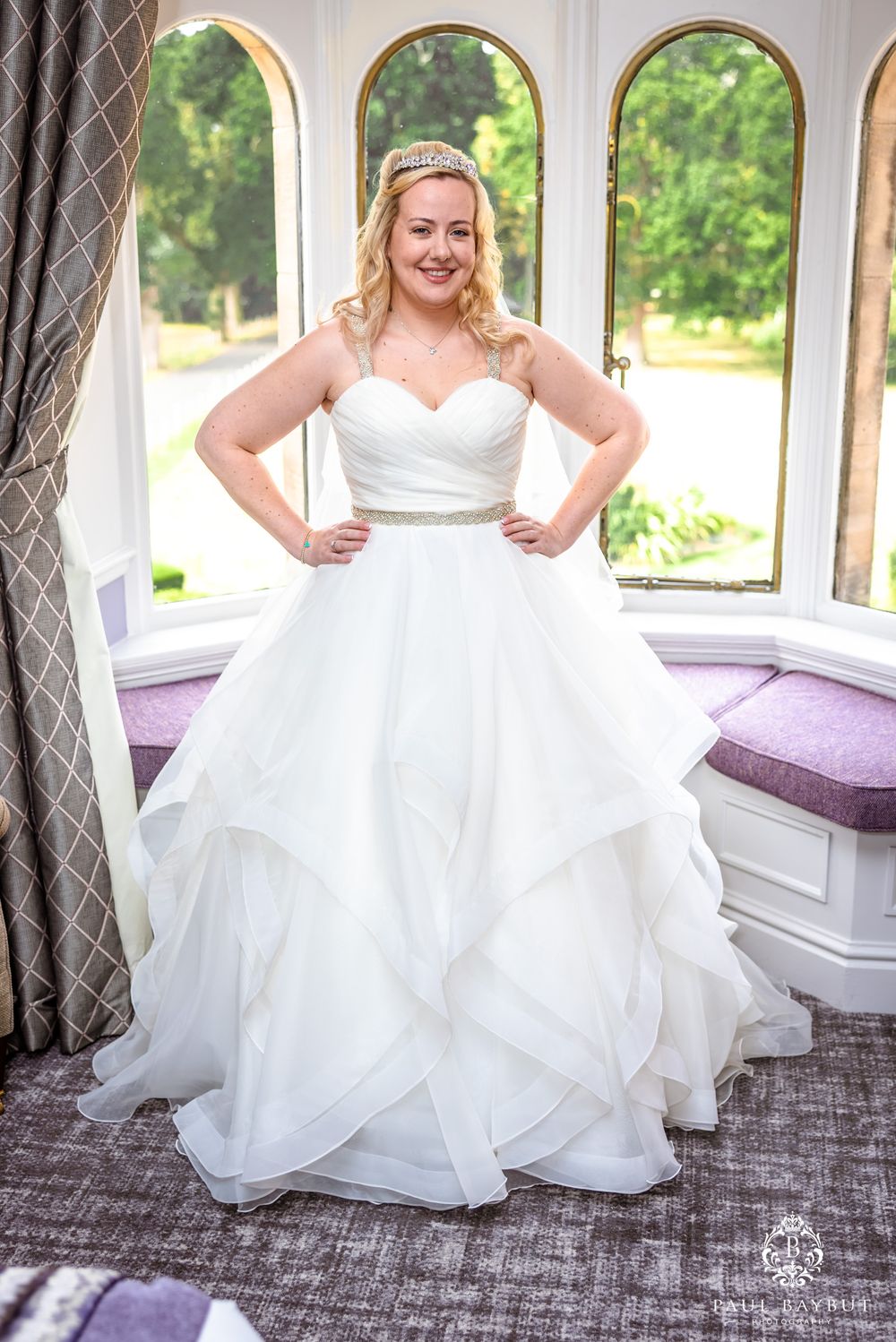 Elegant bridal portrait in front of arched windows with natural lighting.