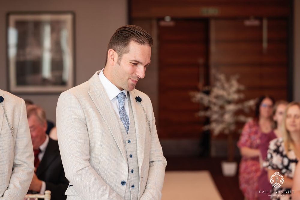 A modern wedding ceremony in progress with light beige and grey formal attire.
