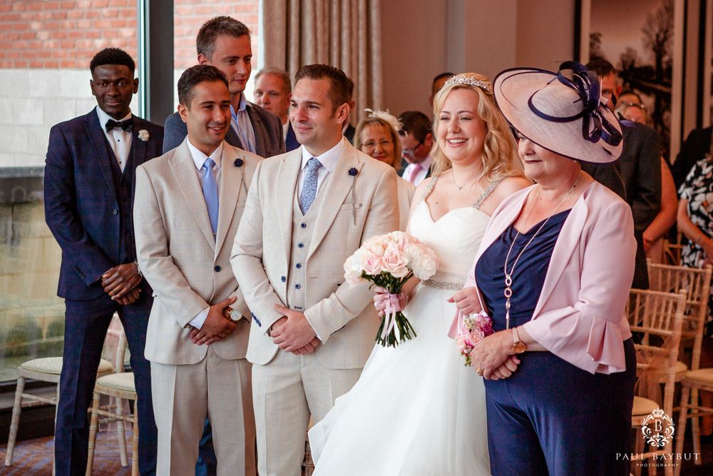 Indoor wedding ceremony with elegant decor and attendants in formal attire.
