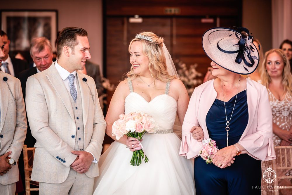 Intimate wedding ceremony moment captured in elegant hotel ballroom setting.