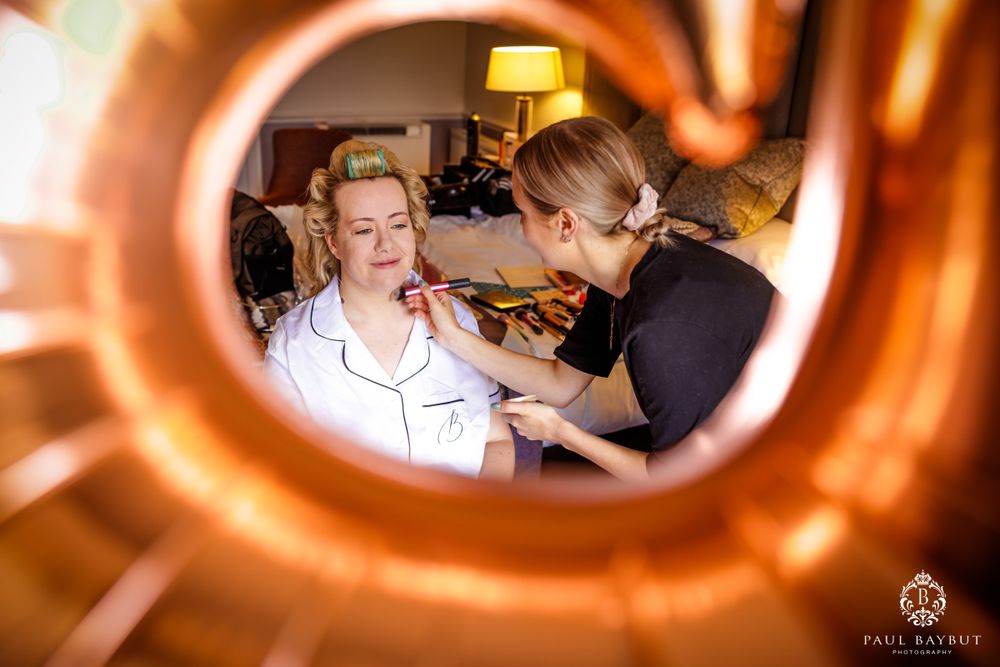 Creative mirror reflection shot of wedding preparation scene with warm lighting.