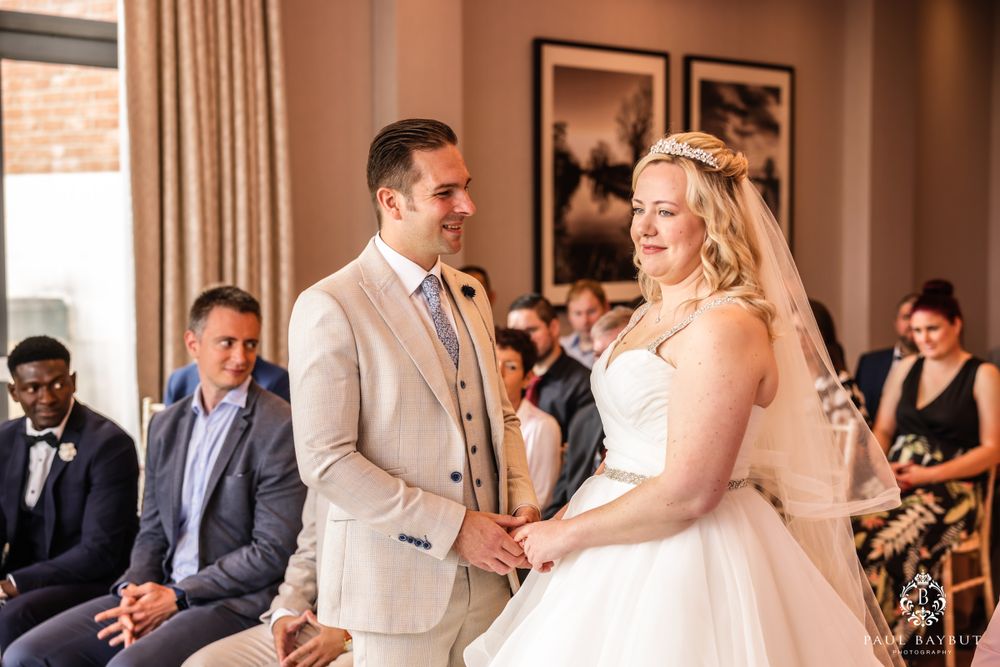 Beautiful indoor wedding ceremony with couple exchanging vows in front of gathered guests.