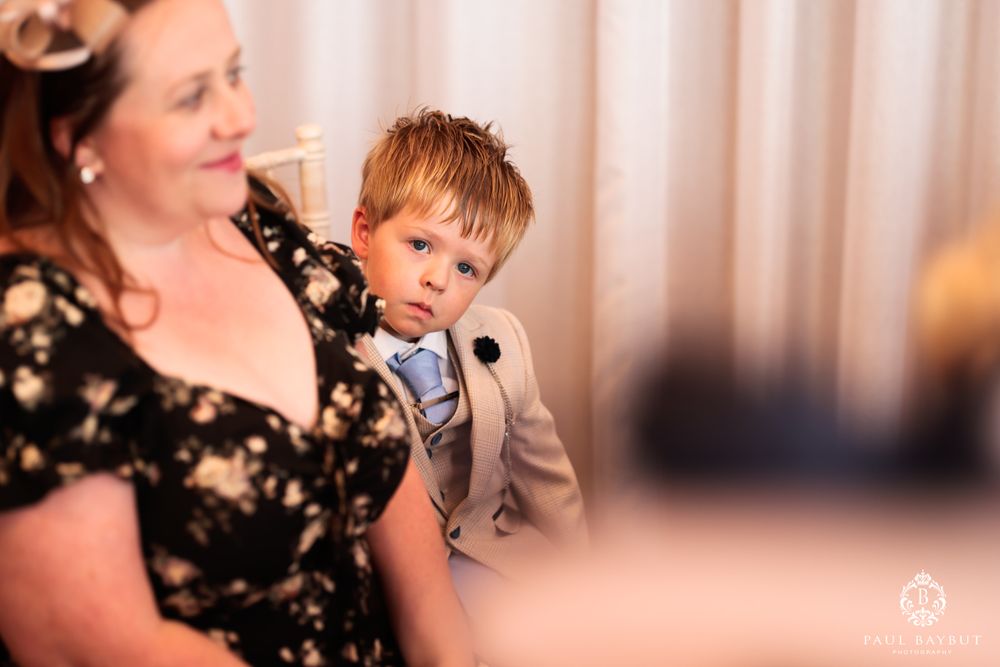 Young guest in formal attire enjoys moment during wedding celebration.