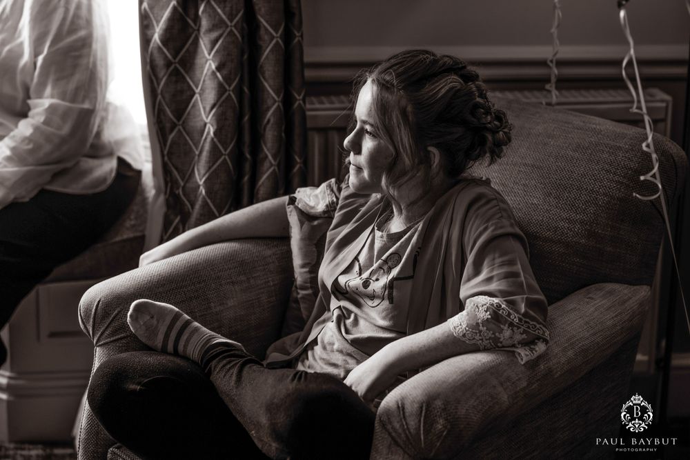 A relaxed black and white portrait of someone getting ready in a hotel room.
