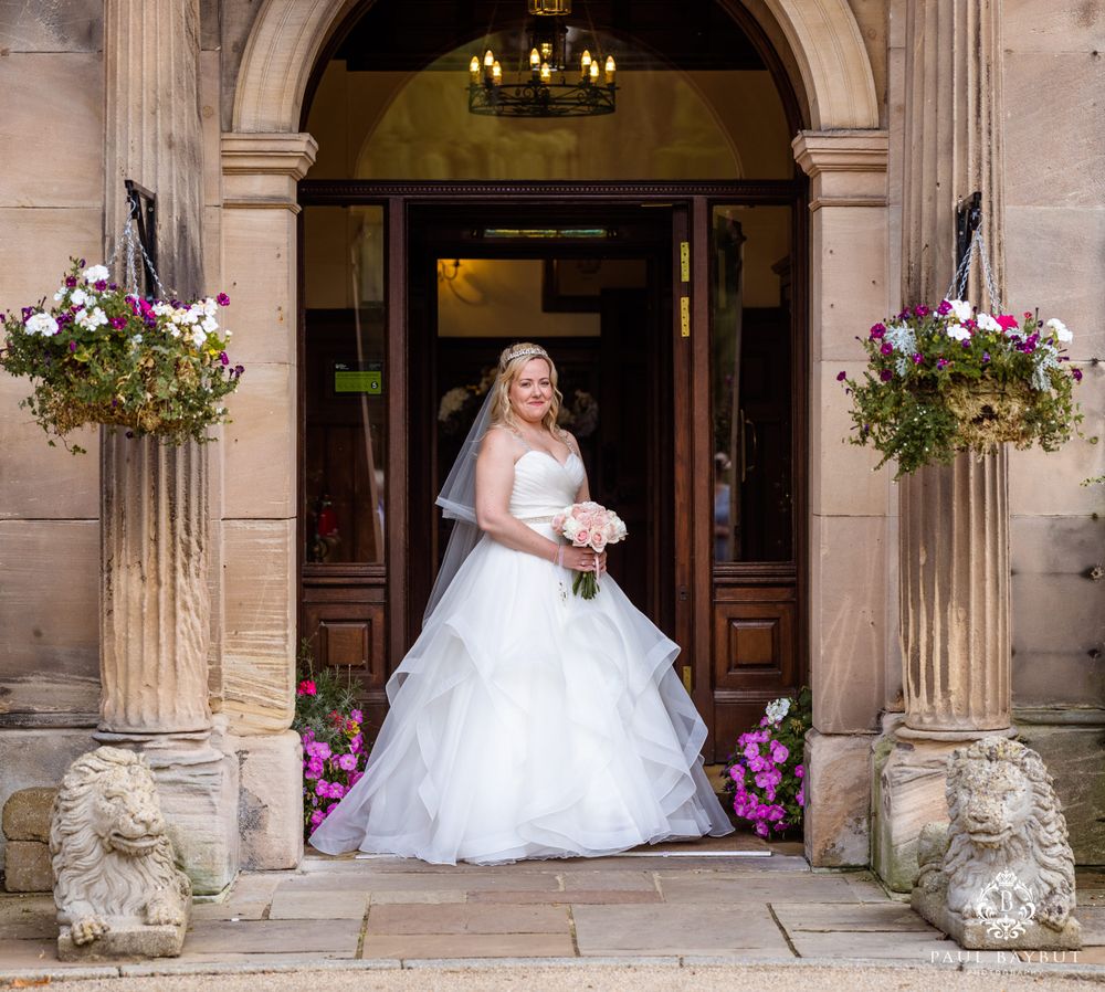 Stunning bridal portrait in stone doorway with hanging baskets and stone lion statues.