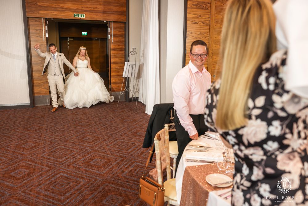 Wedding celebration entrance with couple arriving as guests welcome them.