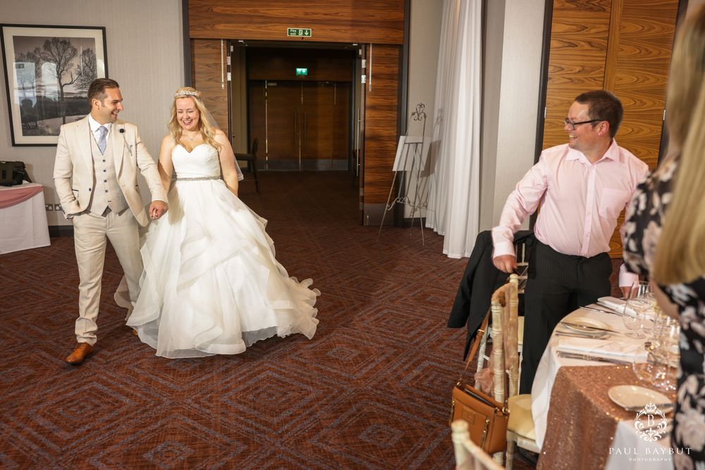 Wedding reception entrance with couple arriving as staff prepare to welcome them.
