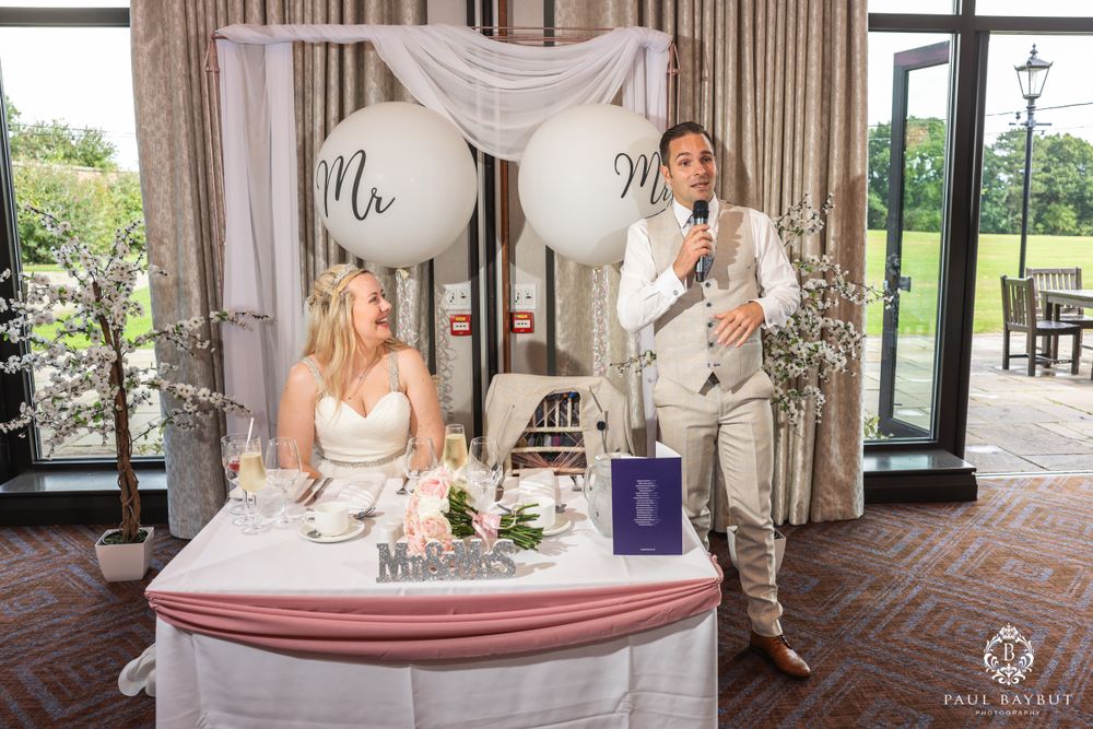Wedding reception setup with Mr and Mrs balloons and white draping in an elegant venue.