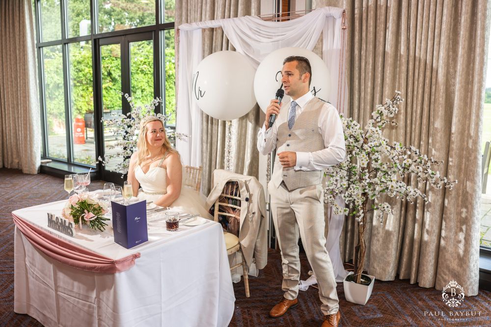 Elegant wedding reception scene with white balloons and decorative floral arrangements.