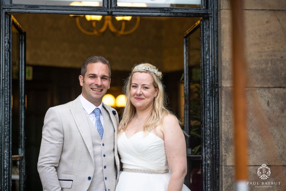 Wedding portrait framed in historic doorway entrance with elegant architectural details.