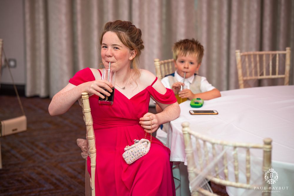 A woman in a red dress and child enjoy themselves at a celebratory event.