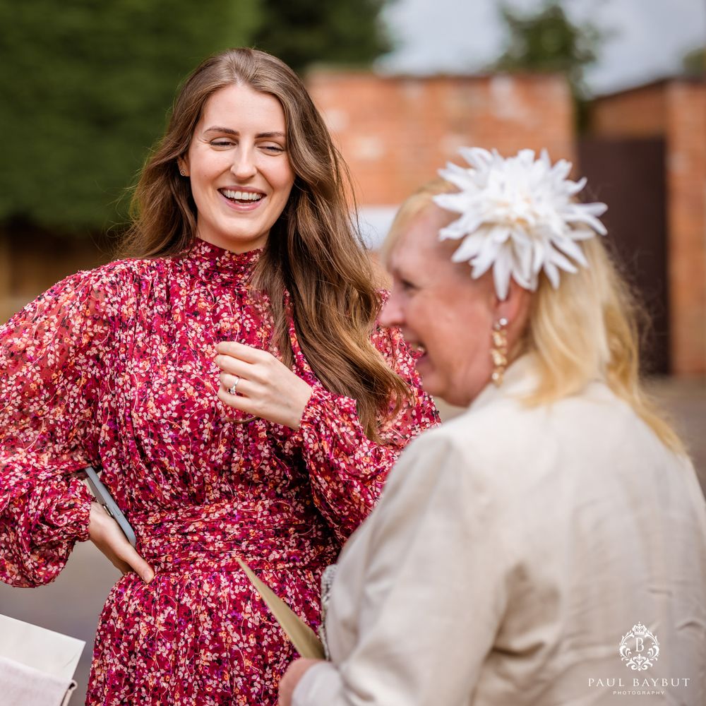 Two event coordinators sharing a lighthearted conversation outdoors.