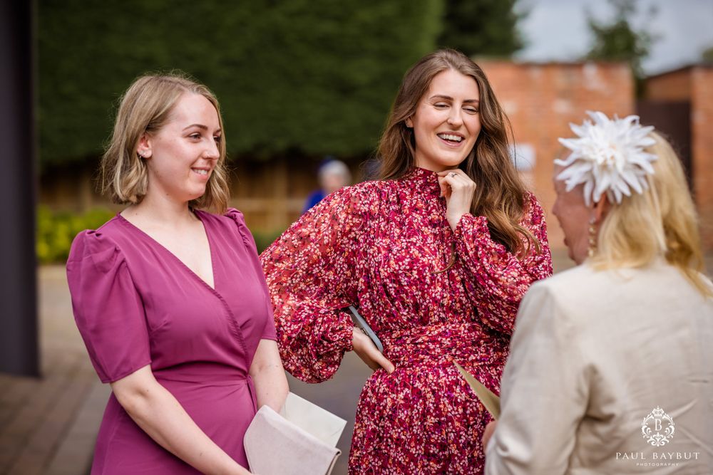 Three event planners sharing a joyful moment during outdoor wedding preparations.