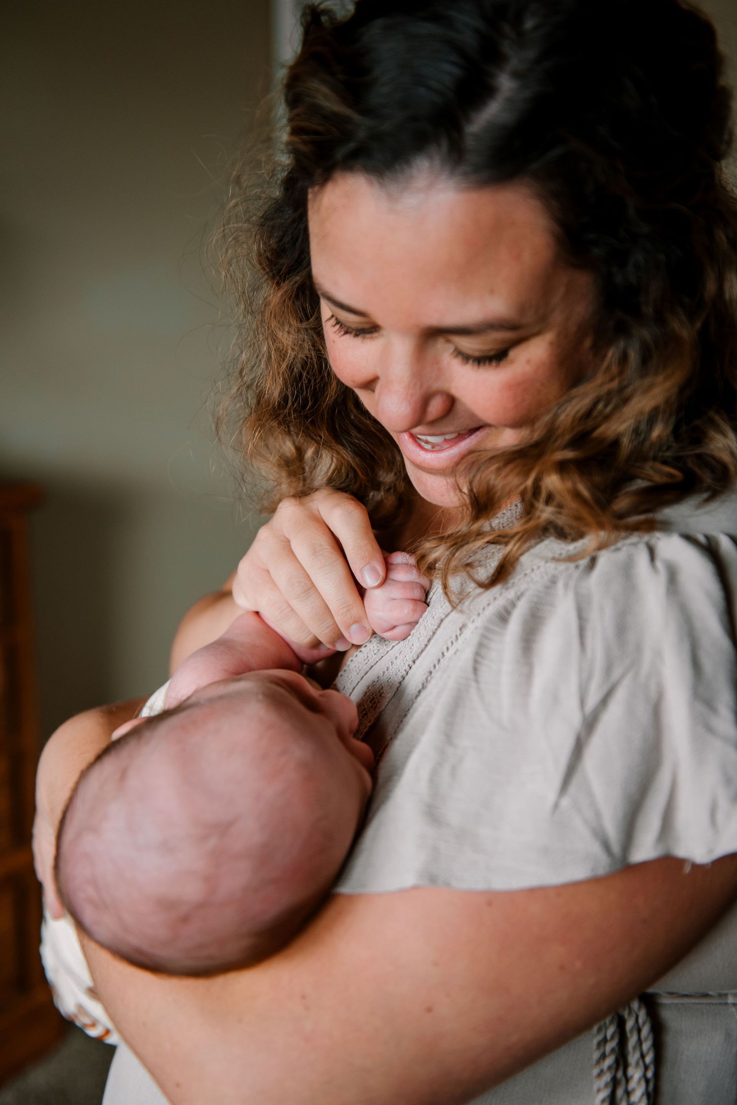 Intimate moment of parent snuggling with newborn baby.