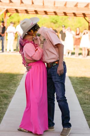 Couple shares intimate moment on sidewalk in outdoor portrait session.