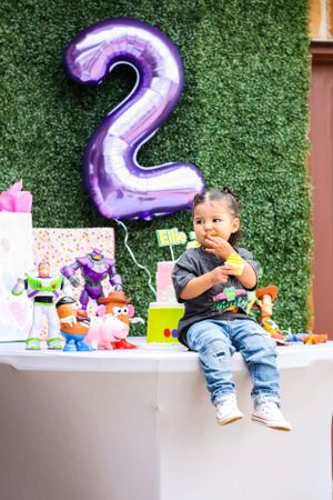 Purple number two balloon and toys displayed at a birthday party setting.