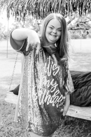 Person wearing sparkly sequined shirt posing playfully.