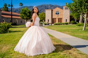 A full pink ballgown against Spanish-style architecture and mountain backdrop. sylmar.