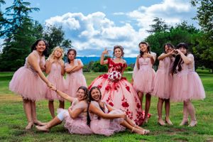 Celebration in a garden featuring pink tulle dresses and a red floral ball gown.