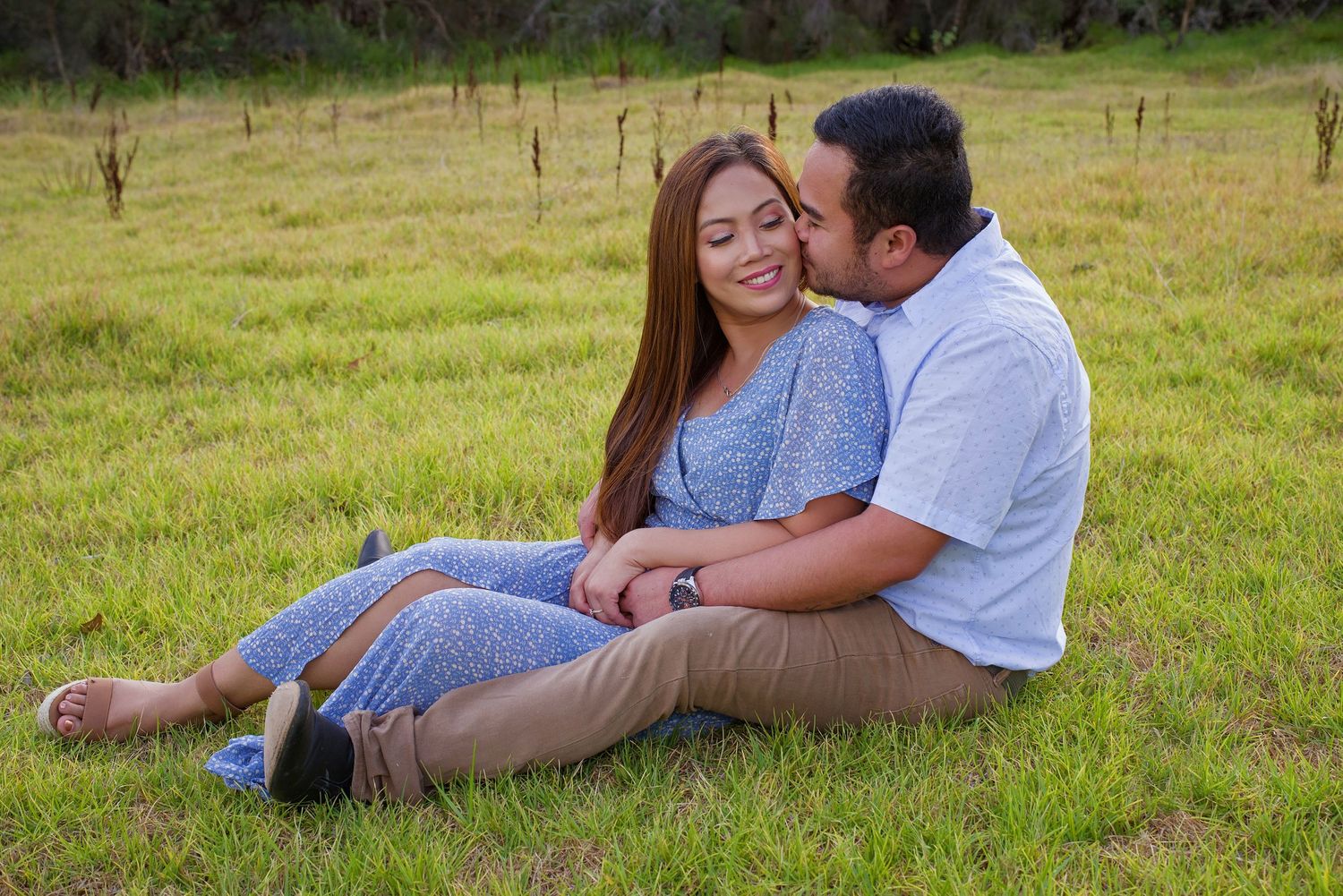 couple laying on grass embracing and kissing