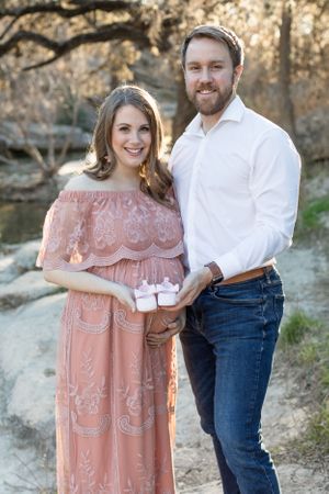 Expecting parents holding pink baby shoes in Austin, Texas