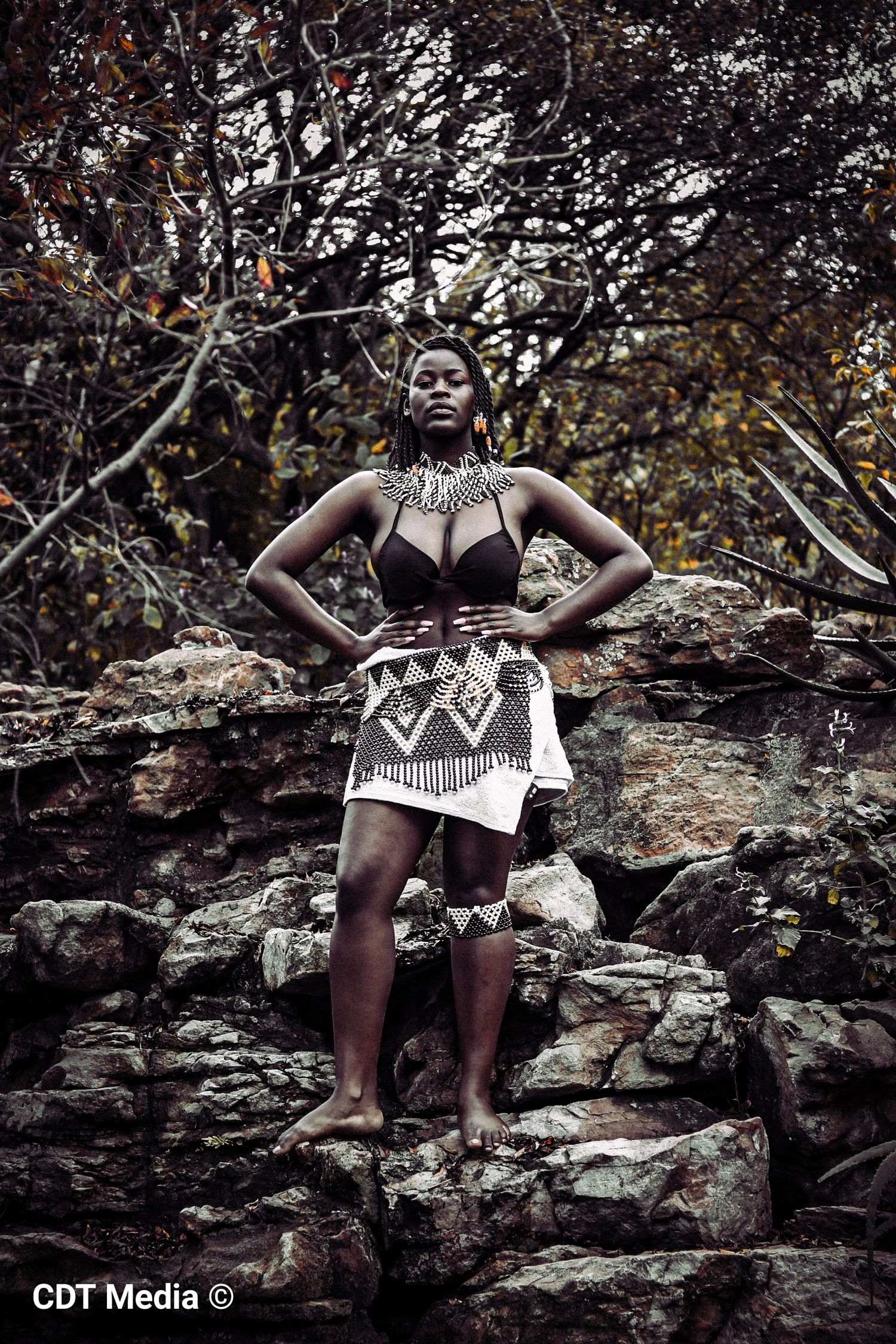 Dramatic traditional photo, of a lady standing in the middle of, and rocks. Celebrating heritage shoot.