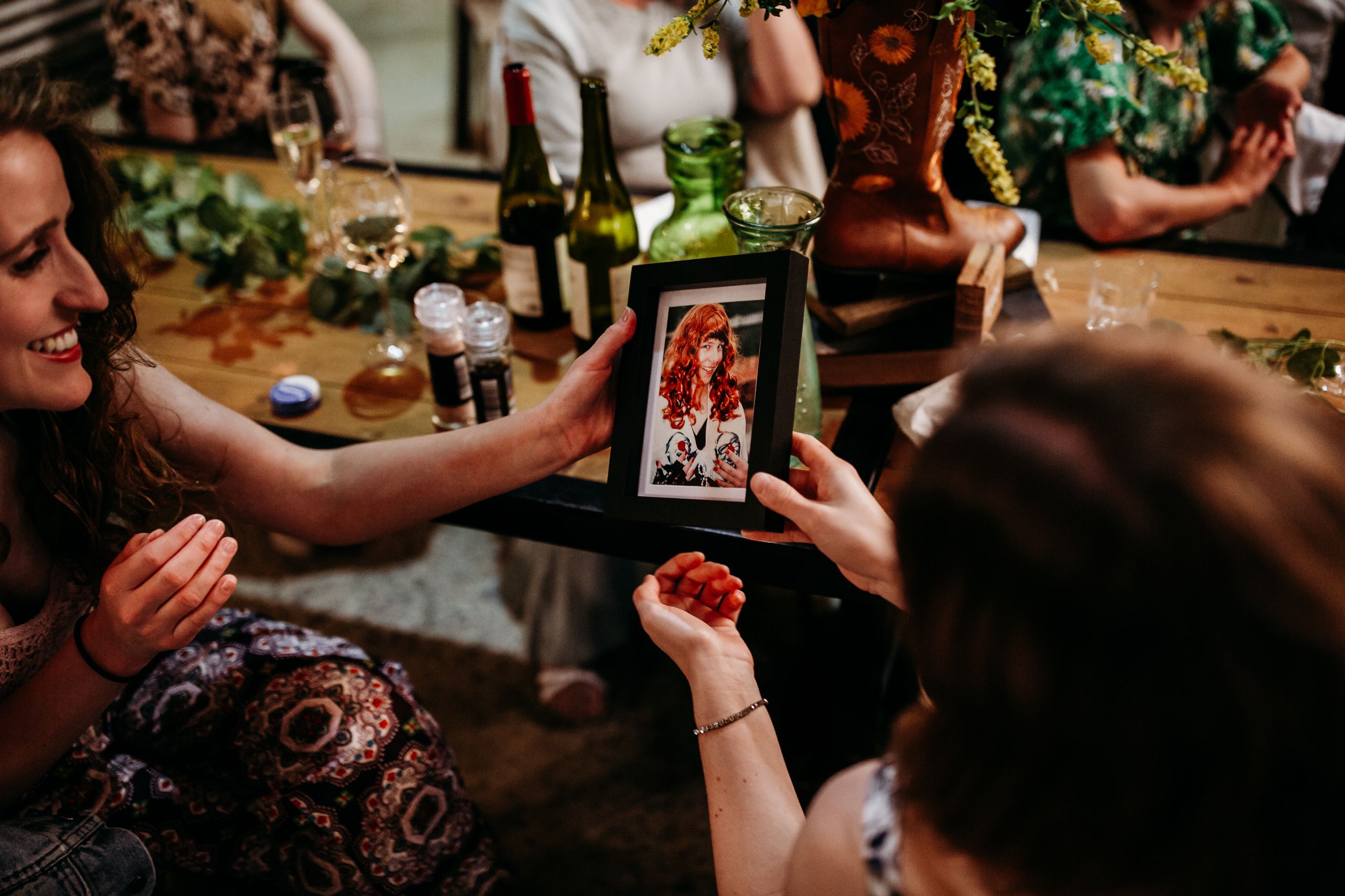 Wedding guests sharing photos and memories on phones during reception celebration.