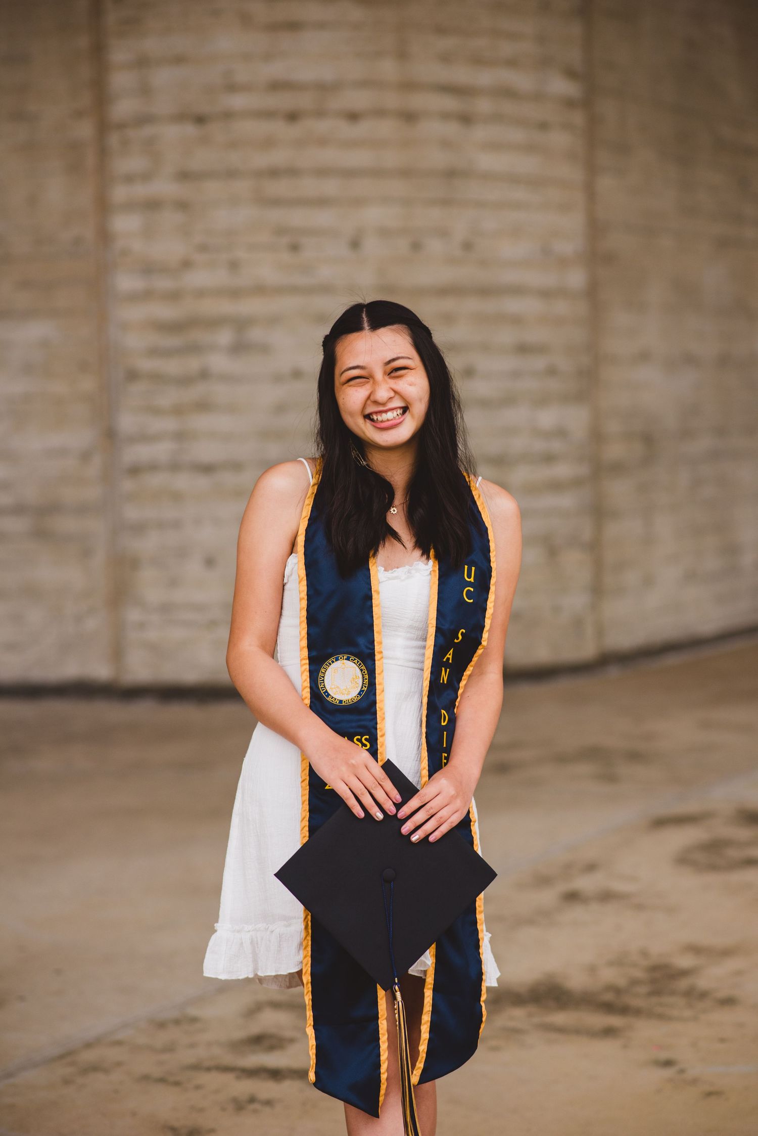 A UCSD grad smiles as she takes her grad photo.