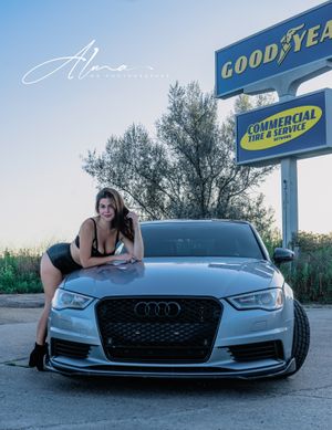 Lifestyle photo with luxury Audi car and Goodyear sign in background.