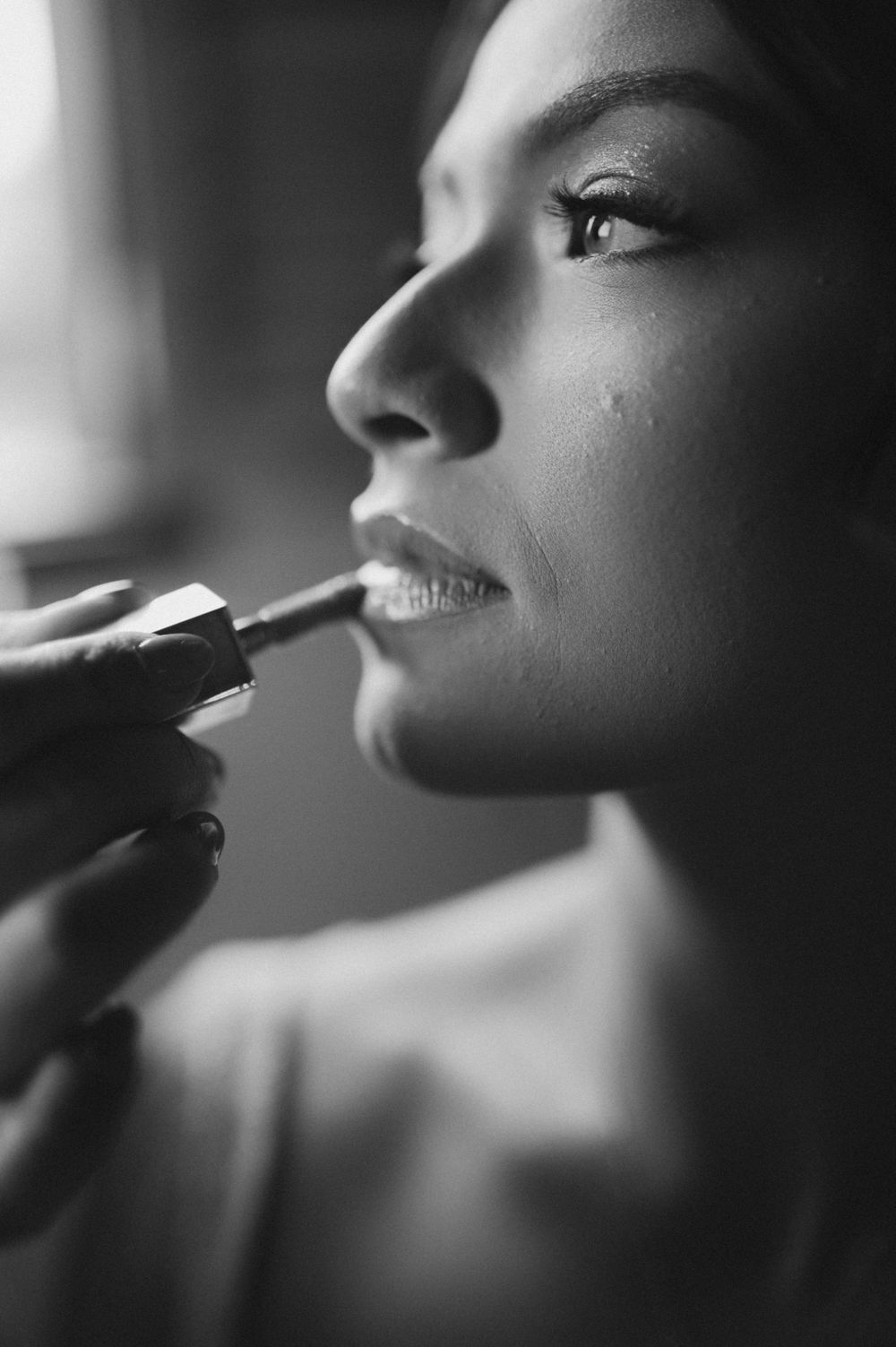 Close-up black and white shot of makeup being applied with a brush.