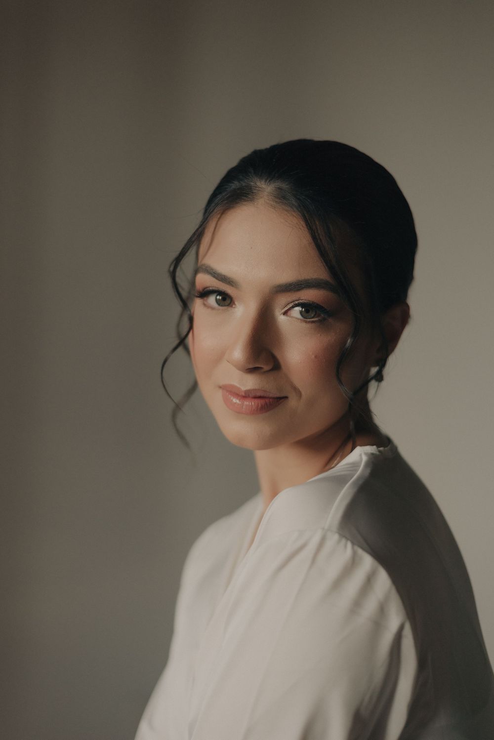 An elegant bridal portrait with soft lighting and natural makeup.
