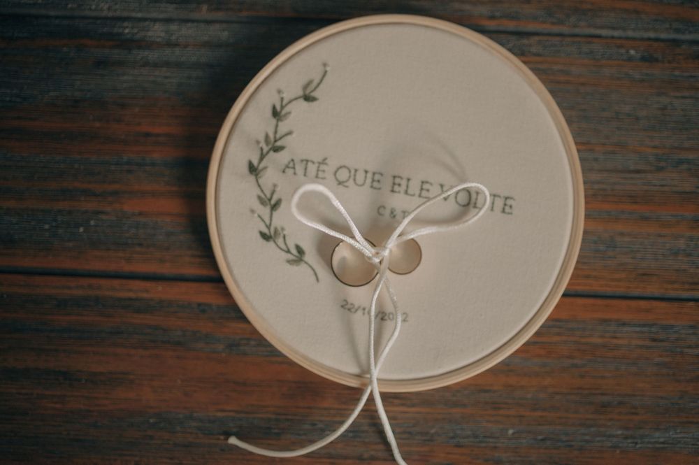 Wedding rings displayed on a decorative circular holder with leaf designs and text.