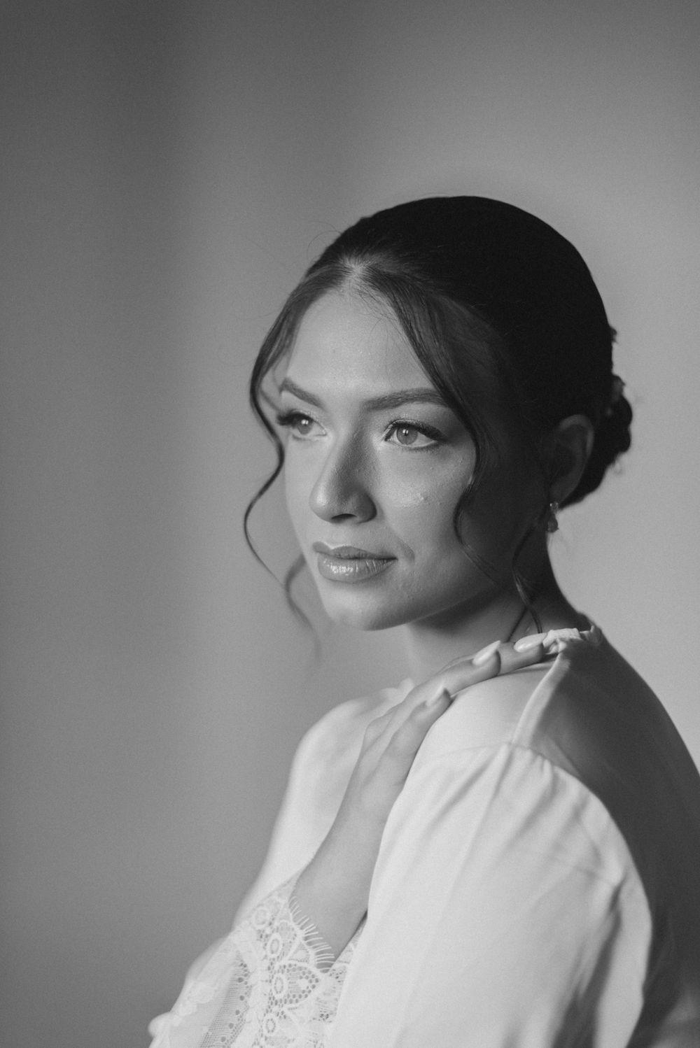 Black and white portrait with soft lighting highlighting elegant styling.