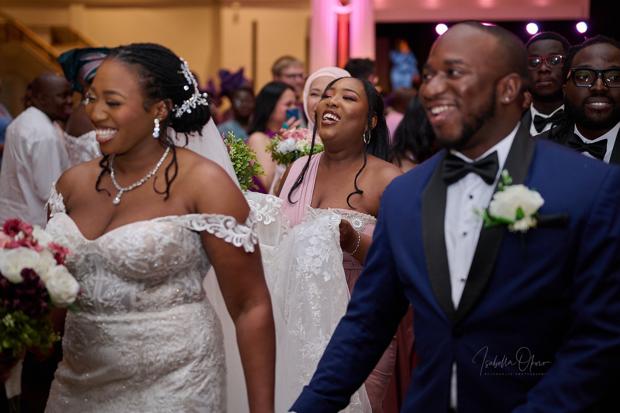 Candid moment of joy and laughter during wedding ceremony with bouquet and formal attire.