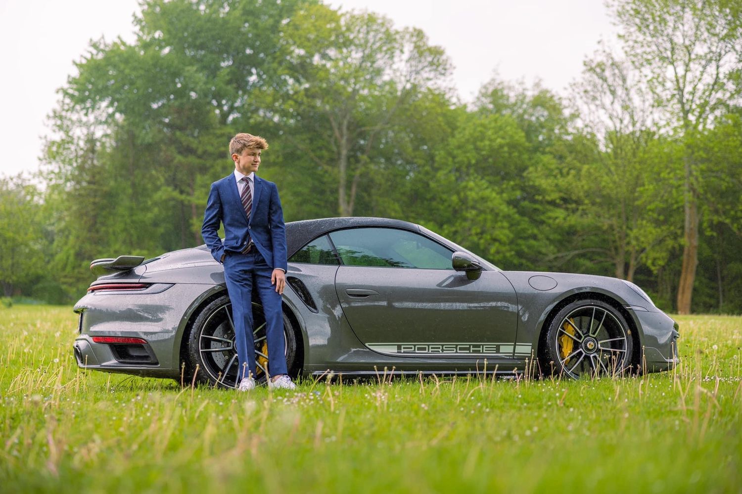 Series of photos showing person posing with luxury sports cars in grassy field.
