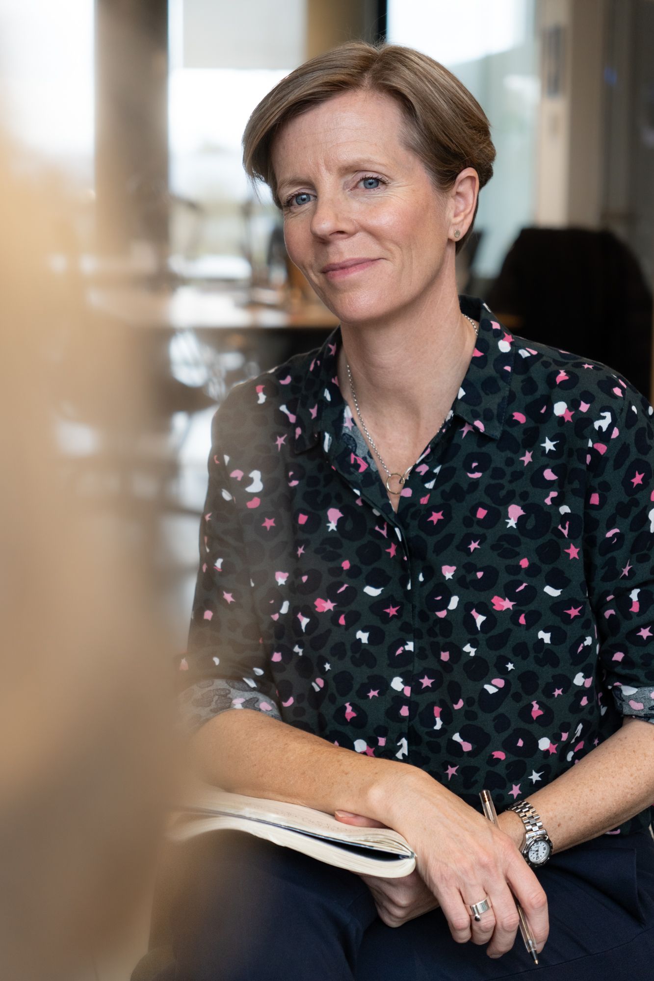 a coach close up of woman smiling wearing patterned top