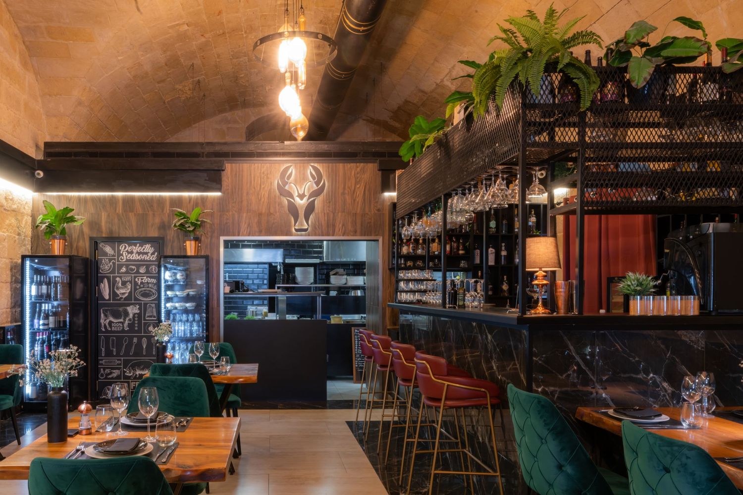 Modern restaurant interior with warm lighting, wooden details, and bar seating.