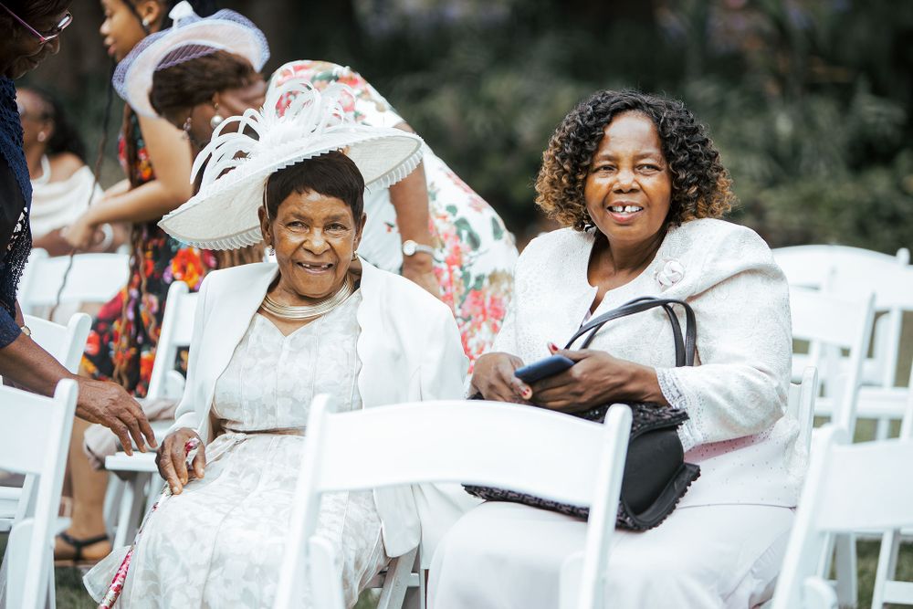Wedding guests in formal attire share joyful moments during outdoor celebration.