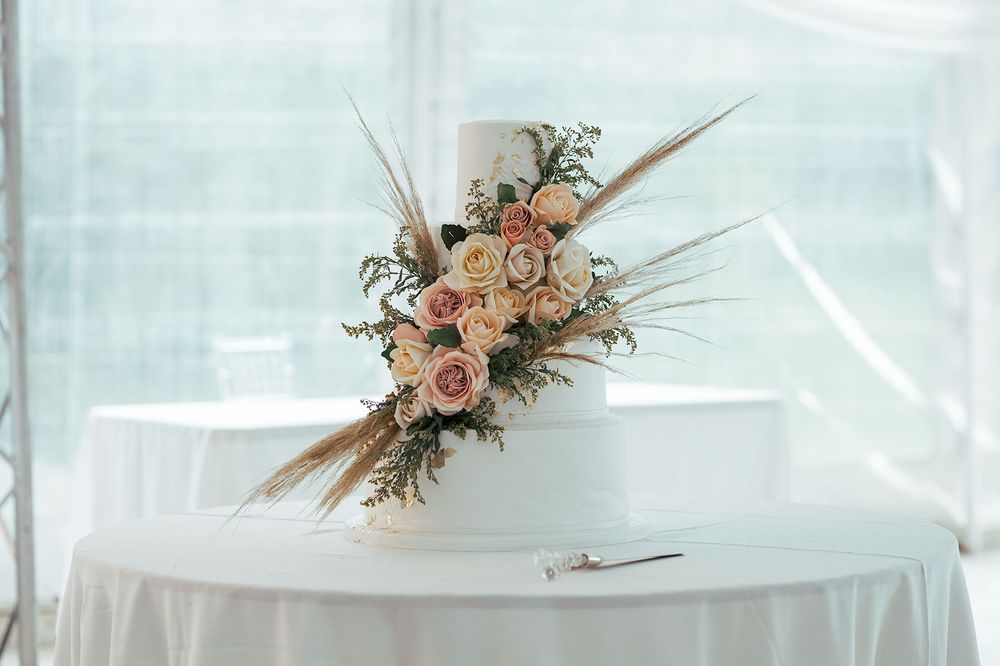 Elegant floral centerpiece with peach roses on white tablecloth.