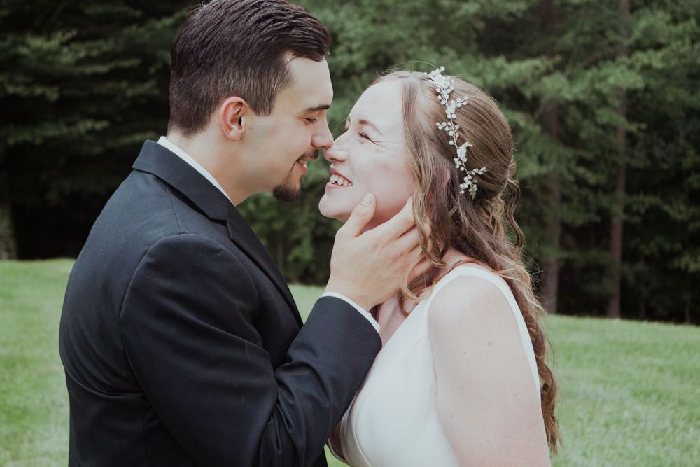 An intimate wedding portrait capturing a tender moment outdoors.