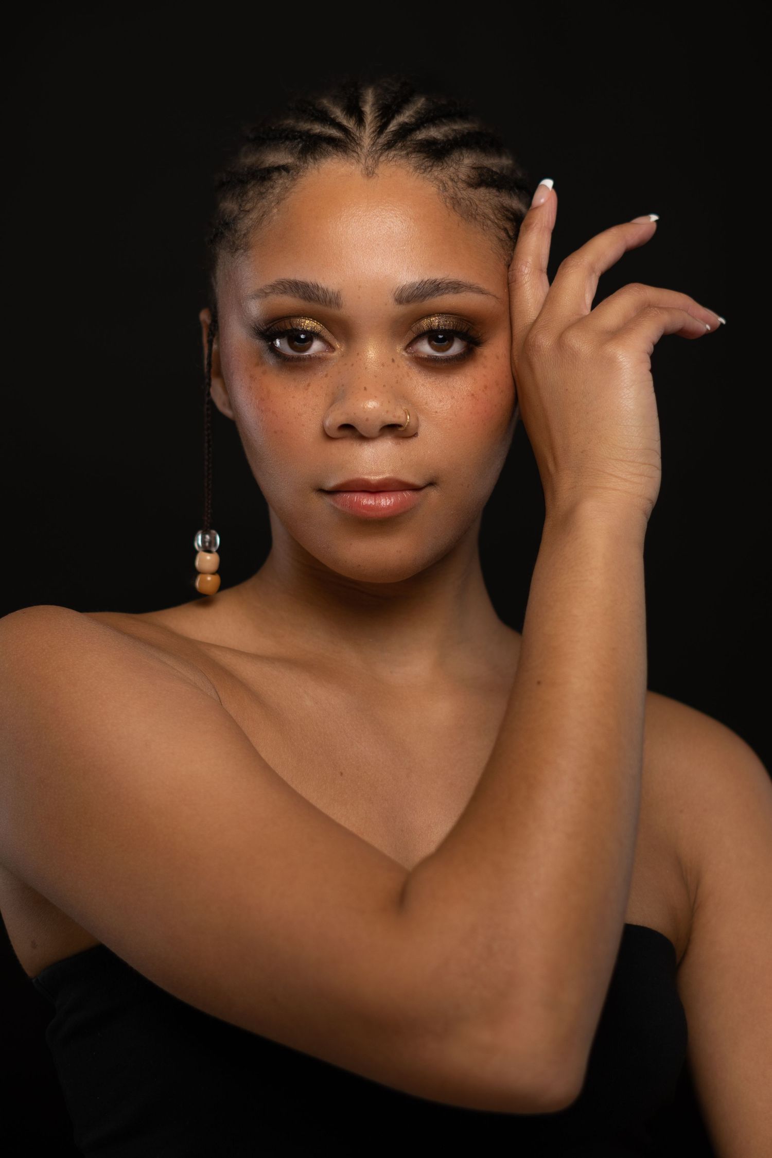 Artistic beauty portraits with dramatic lighting highlighting facial features against dark background.