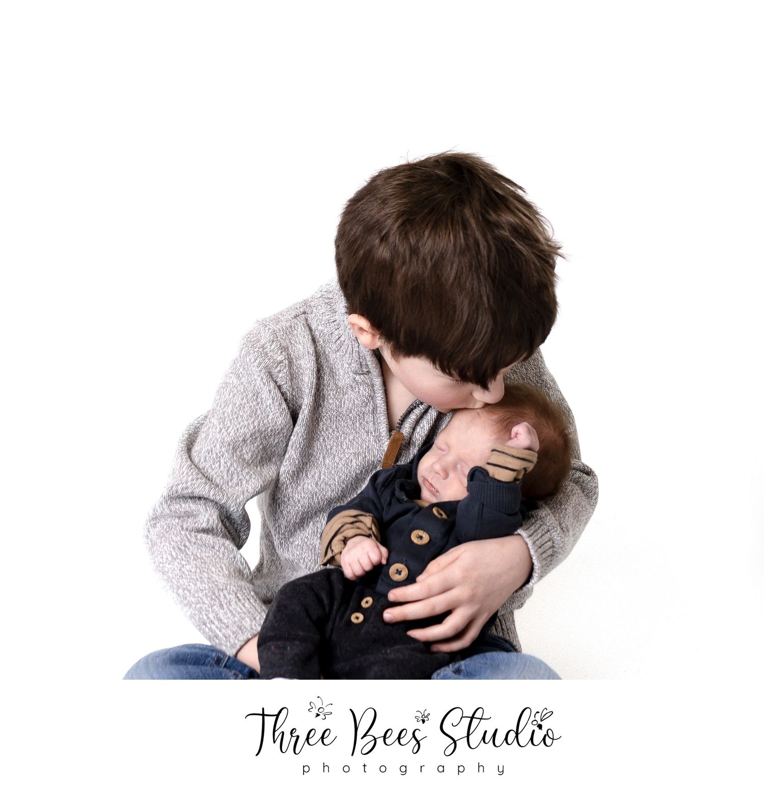 Tender moment between siblings with older child embracing younger one.