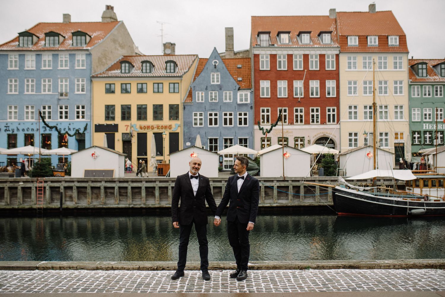 A gay couple on their wedding day posing in front of Nyhavn in Copenhagen
