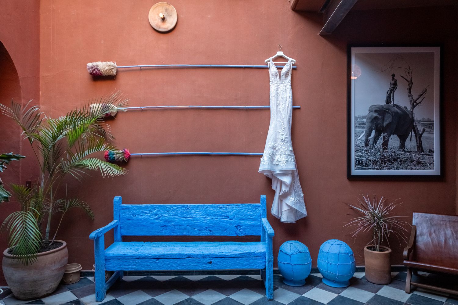 Rustic terracotta wall with blue bench and decorative garden elements.