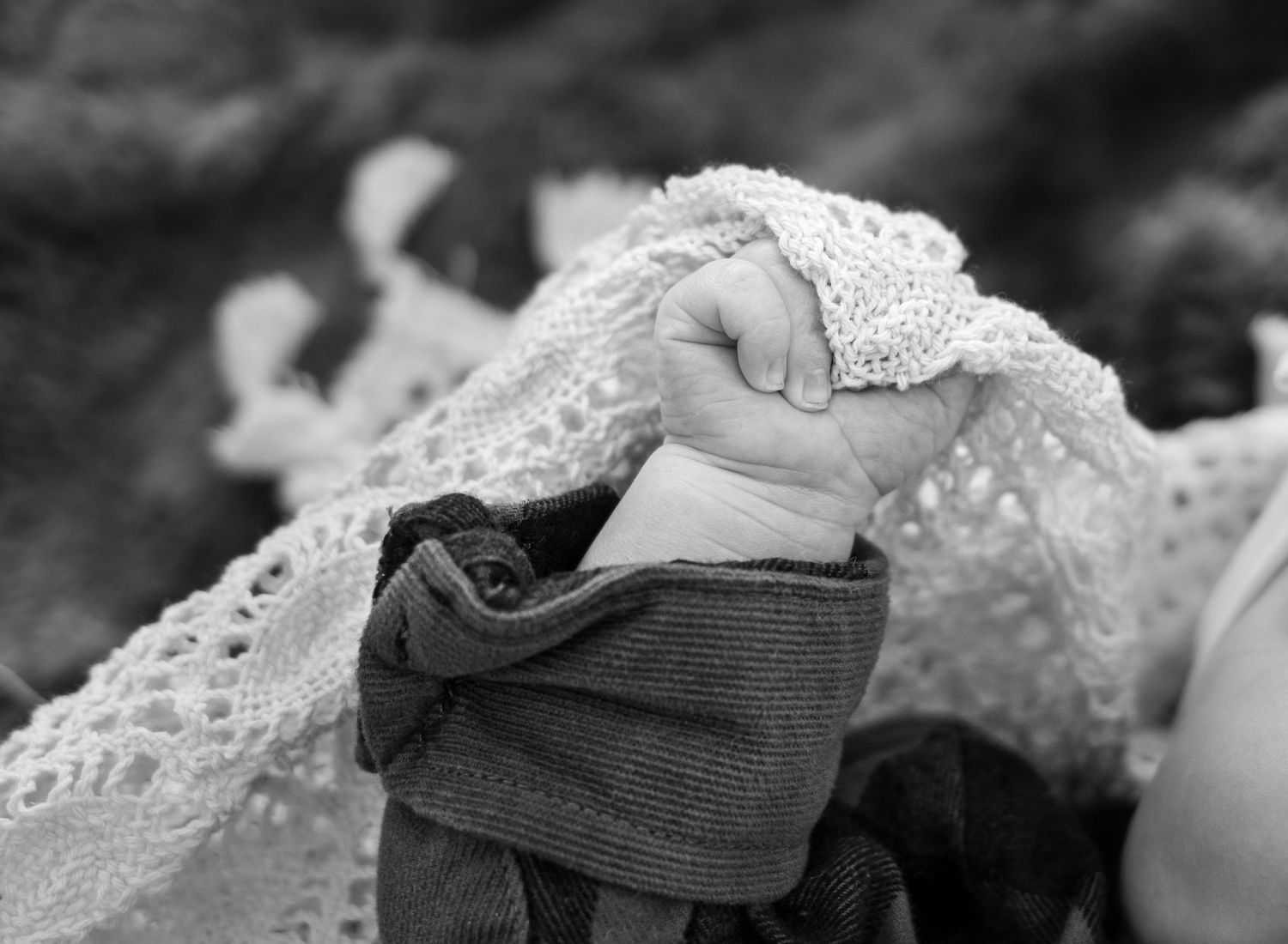 newborn baby hand, detailed shot, holding a blanket.